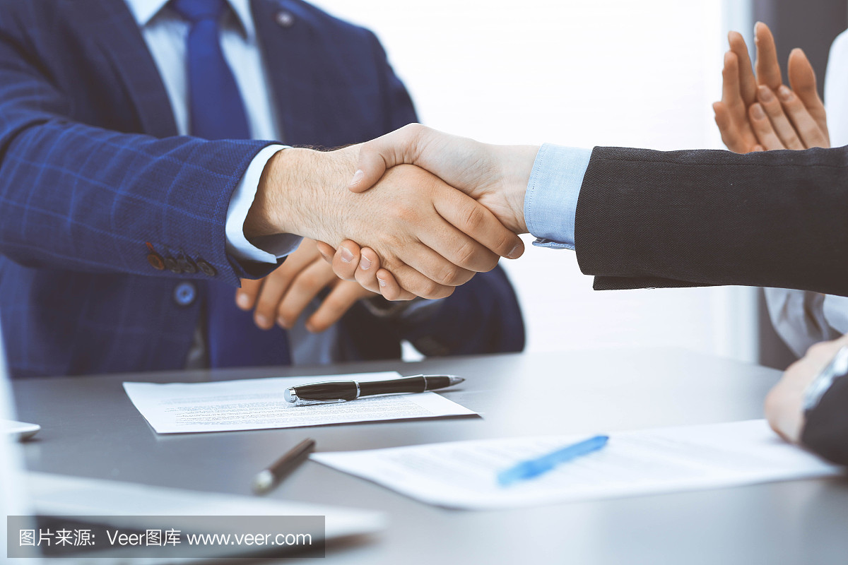商人們握手,完成一份文件簽名。會(huì)議、合同及律師咨詢(xún)理念